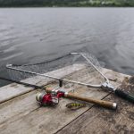 fishing-rod-with-lure-net-wooden-pier-idyllic-lake